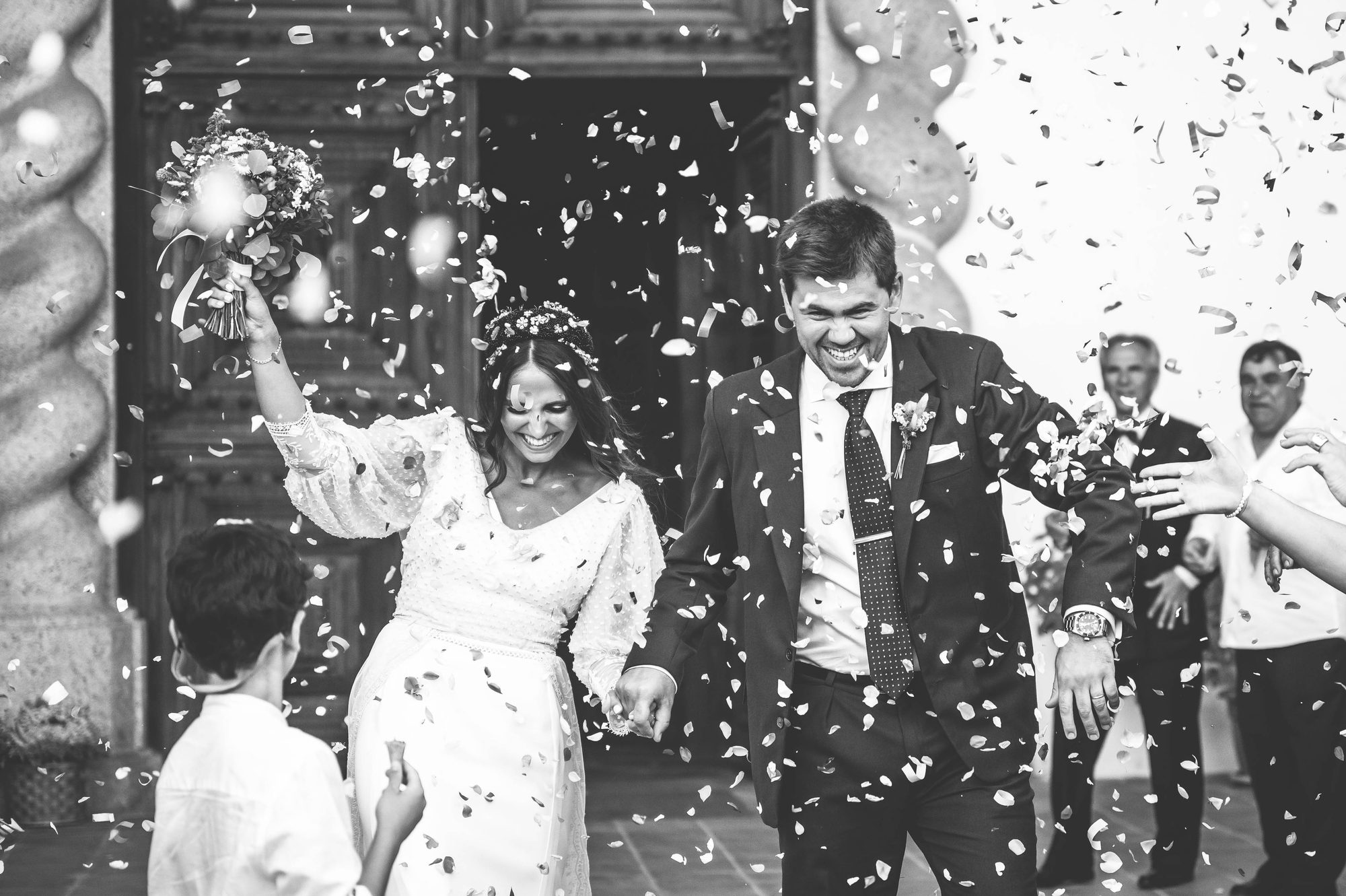 Noivos à saída da igreja sob uma chuva de confettis